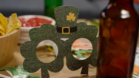 Close-Up-Of-Irish-Novelties-And-Props-Including-Shamrock-Shaped-Glasses-Celebrating-At-St-Patrick's-Day-Party